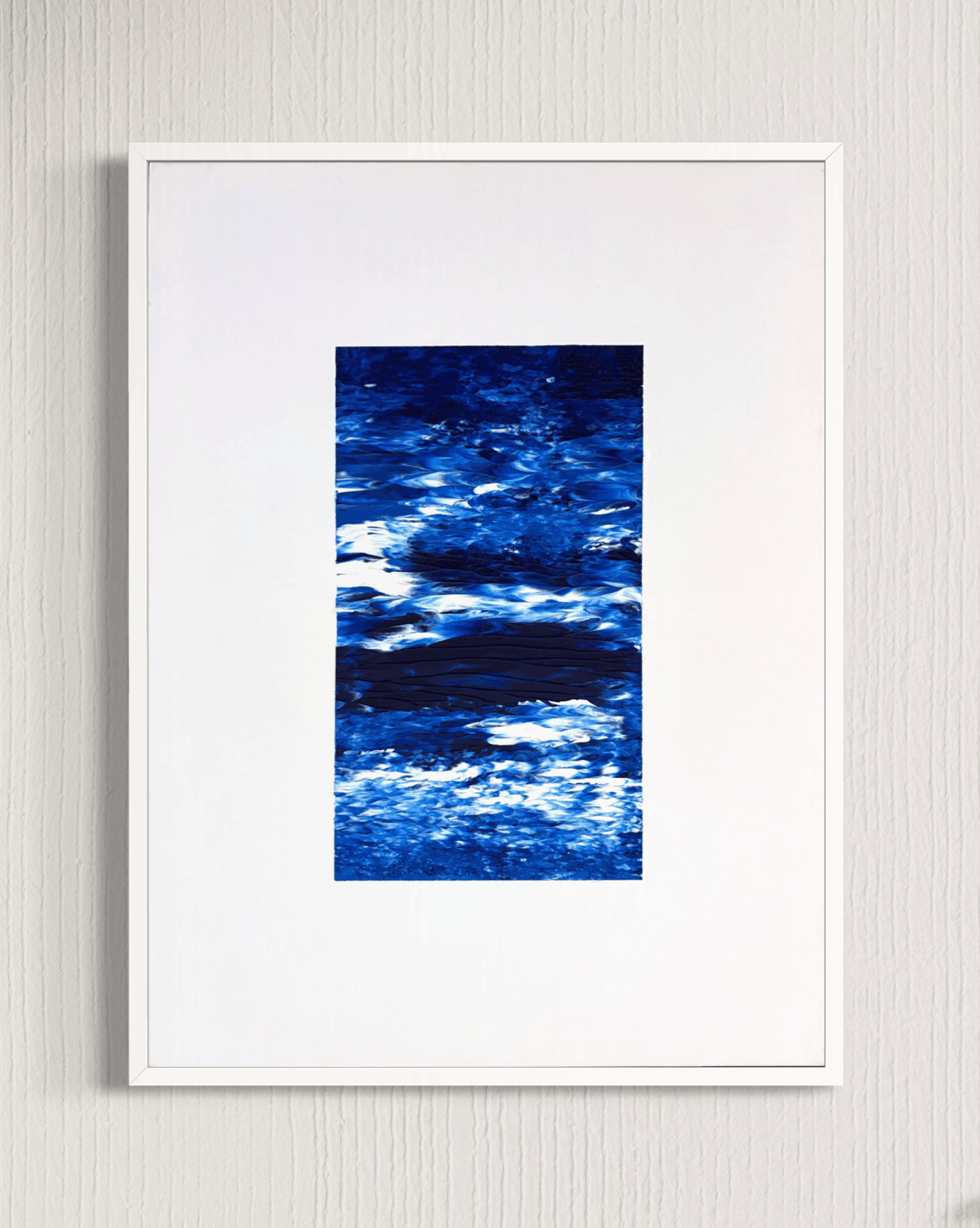 A framed abstract art print featuring textured blue and white brushstrokes, presented in a white frame against a light gray textured wall.