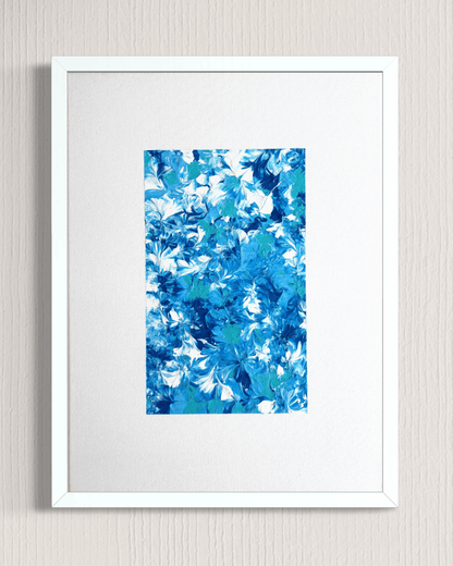 A framed abstract art print featuring a vibrant blue and white floral pattern, presented in a white frame with a white mat against a light gray textured wall.