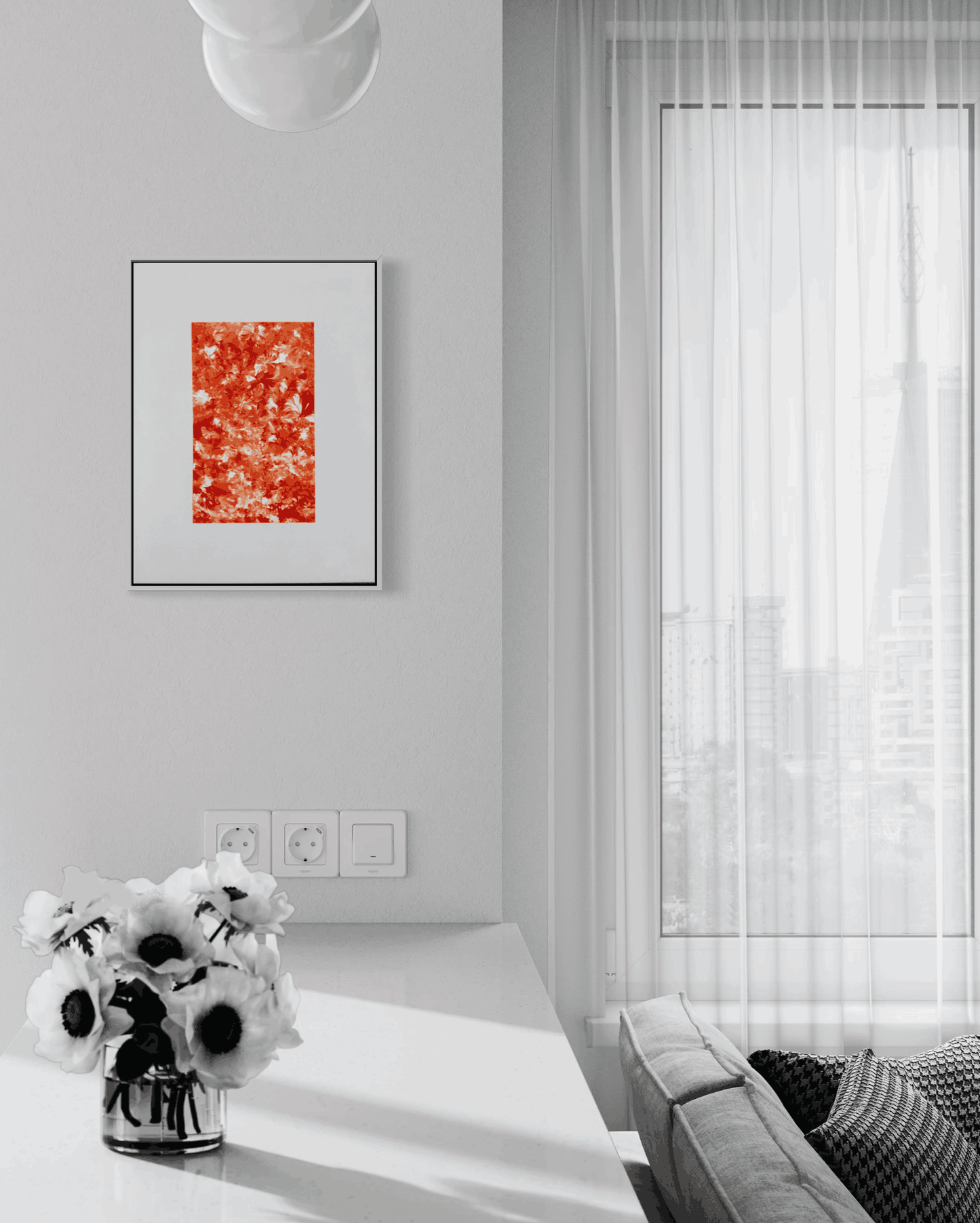 A framed abstract art print with a vibrant red and orange textured design, displayed on a light gray wall in a modern, minimalist living room setting.