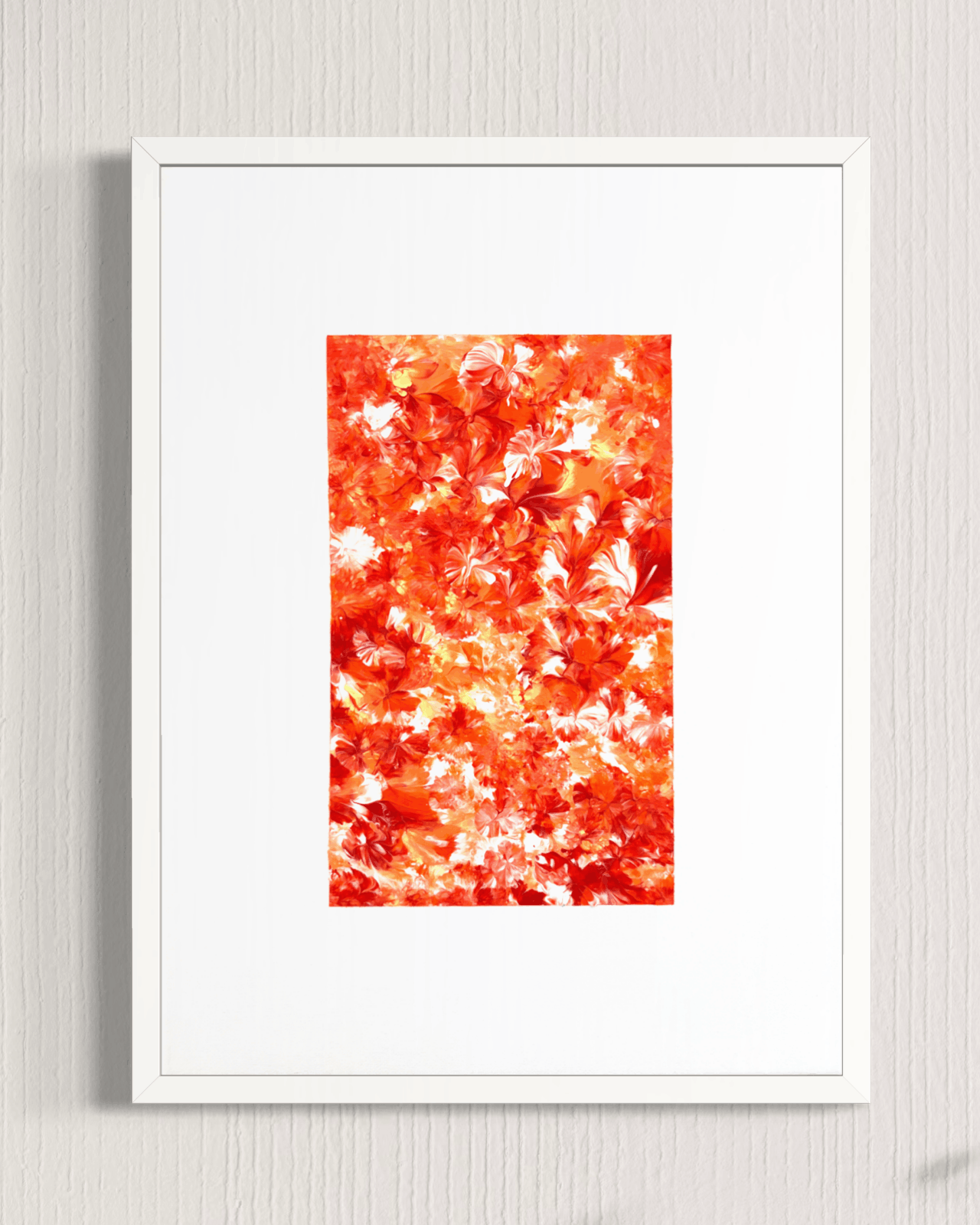 A framed art print featuring a dense pattern of red, orange, and white autumn leaves, presented in a white frame against a light gray textured wall.