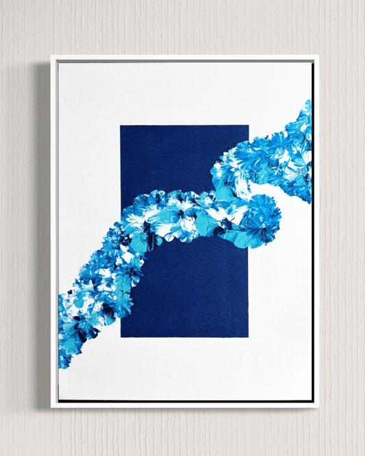 A framed abstract art print featuring a dark navy blue rectangle and a diagonal wave-like pattern of textured blue and white flowers, set against a light gray textured wall.