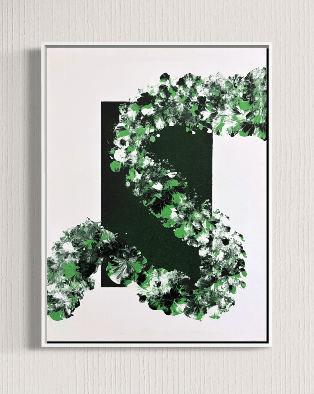 A framed abstract art print featuring a stylized green letter 'S' composed of textured green, white, and black brushstrokes on a white background, enclosed in a thin black frame and mounted on a light gray textured wall.