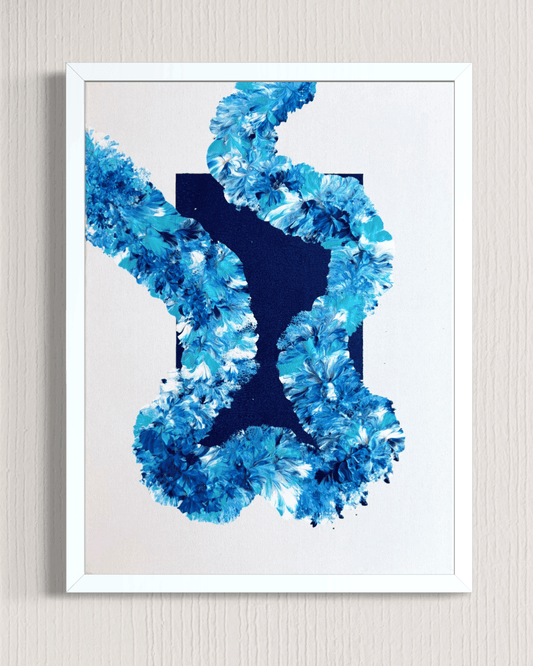 A framed abstract art print featuring a textured blue floral or coral-like pattern around a dark navy central shape, set against a white background and mounted on a light beige wall.