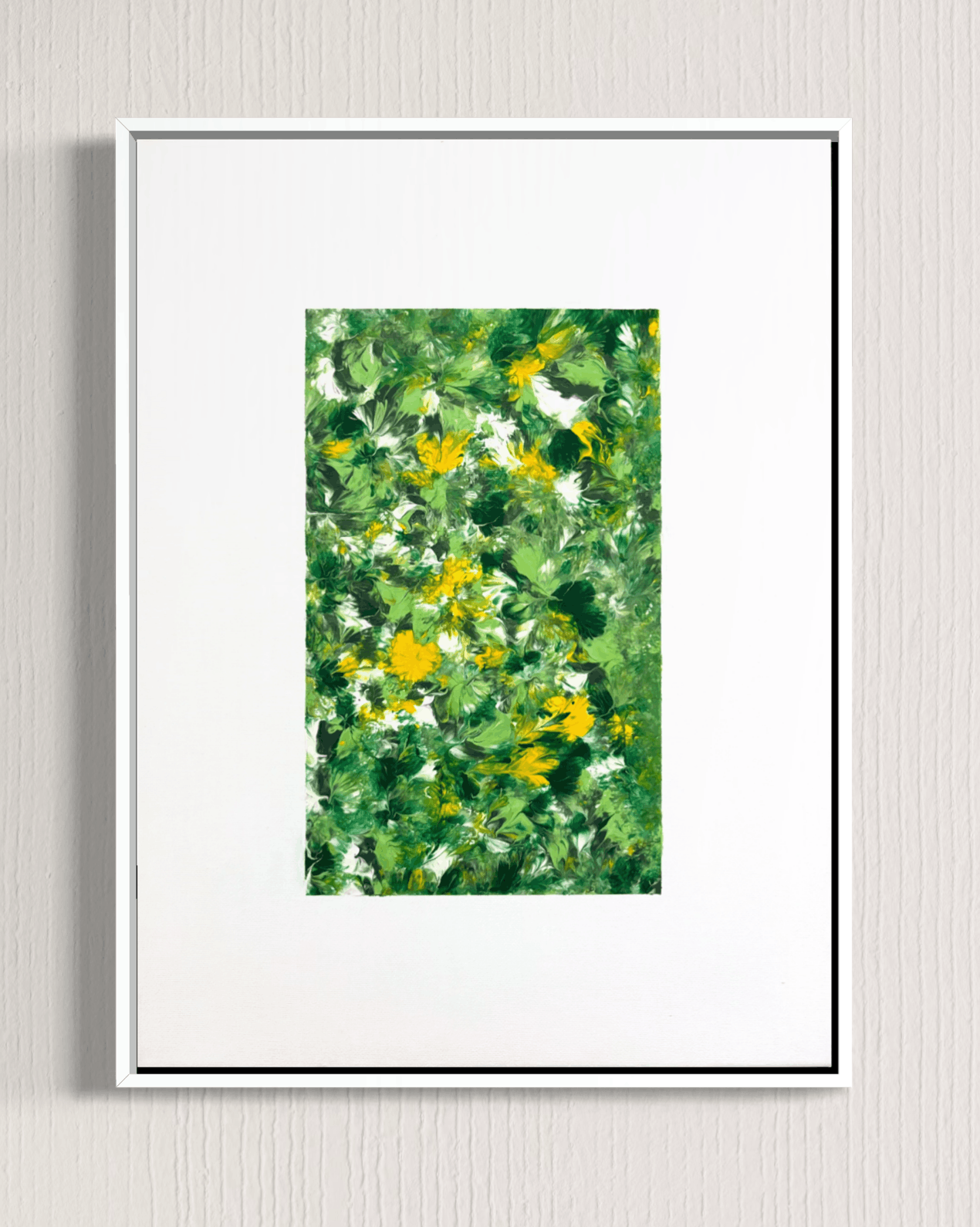 A framed botanical art print featuring an impressionistic green and yellow flower pattern, presented in a white frame with a wide white mat against a light gray textured wall.