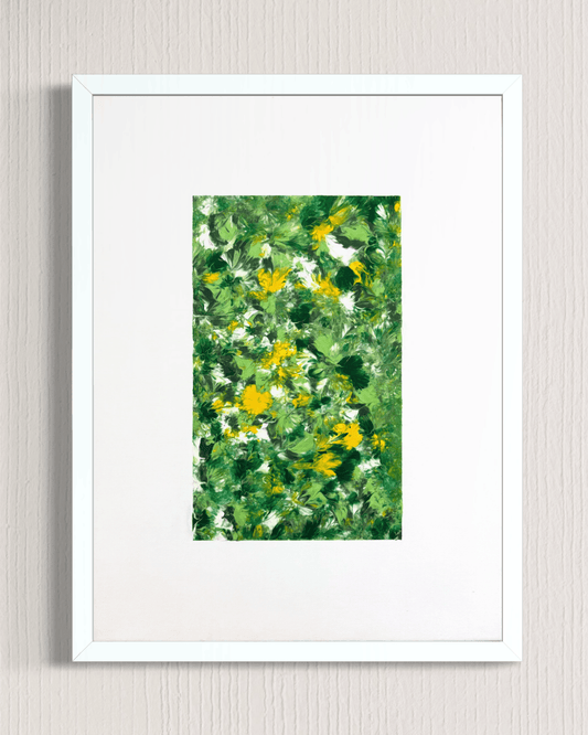 A framed art print featuring an abstract green and yellow floral pattern, presented in a white frame with a white mat against a light gray textured wall.