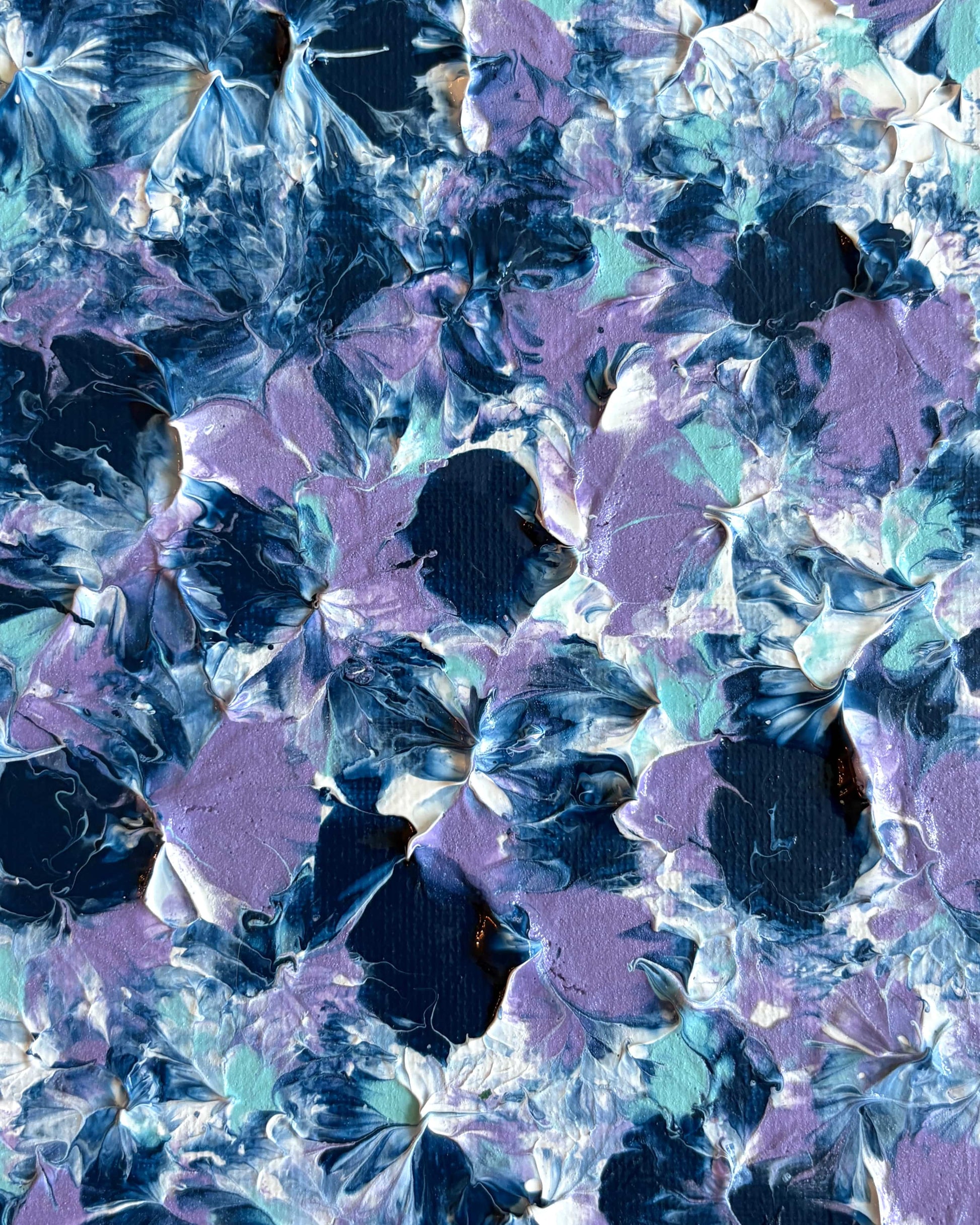 Abstract floral artwork with layered painted blossoms in blue, purple, white, and teal tones filling the frame.