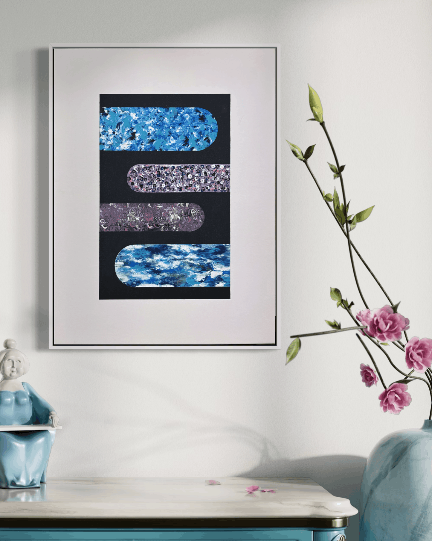 Framed abstract wall art hanging on a white wall above a turquoise console table, with a vase of pink flowers and a decorative object in the room. The artwork features four horizontal rounded rectangular panels in blue, purple, and black.