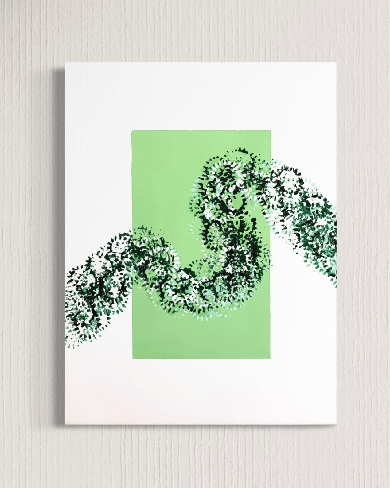 A minimalist art print featuring a light green square with a dark green and white textured, leaf-like snake-like form winding across it, displayed on a light gray textured wall.